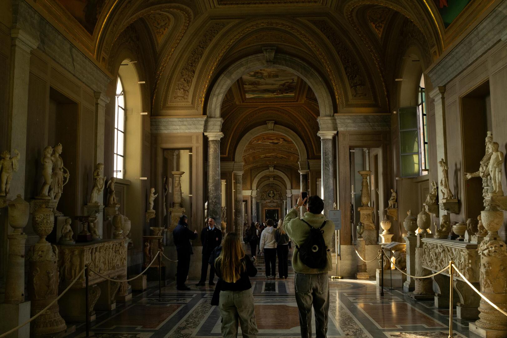 Vatican Museums galleries with classical sculptures and paintings